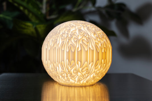 biomorphic sculptural mini lamp with organic flowing surface and warm glowing light