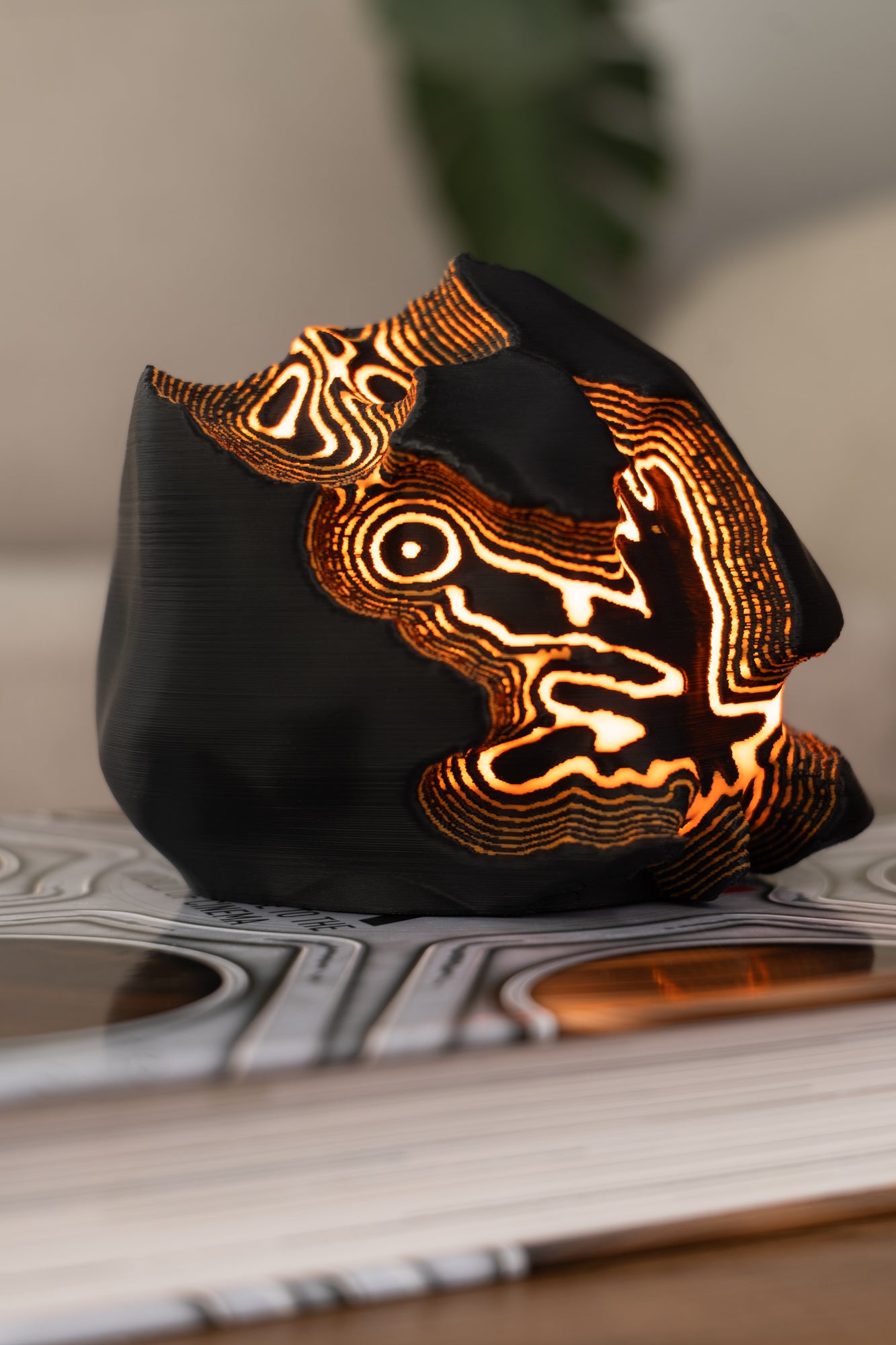 Black lamp with intricate orange patterns on a book