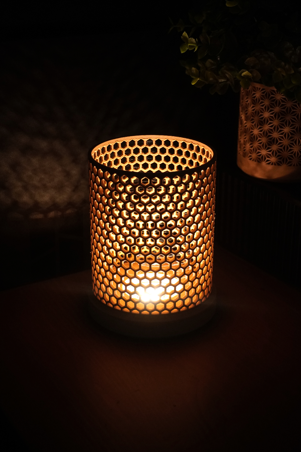 Decorative candle holder with a honeycomb pattern in a dark setting