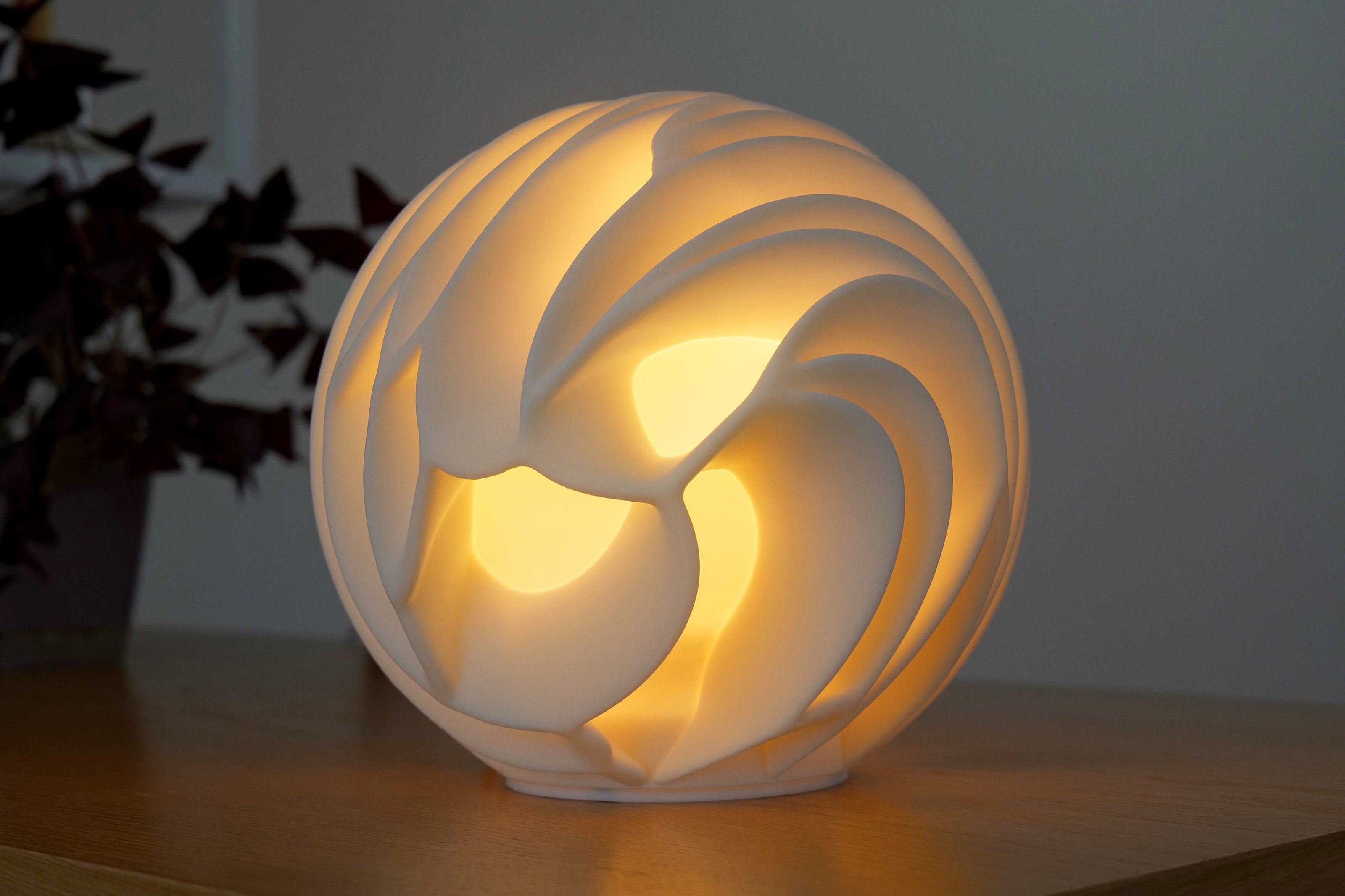 Decorative spherical lamp with a swirling design on a wooden surface.