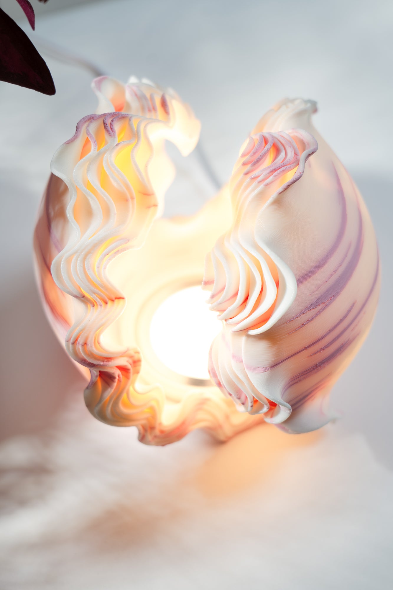 Decorative lamp with swirling design on a plain background