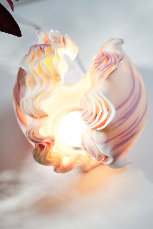 Decorative lamp with swirling design on a plain background