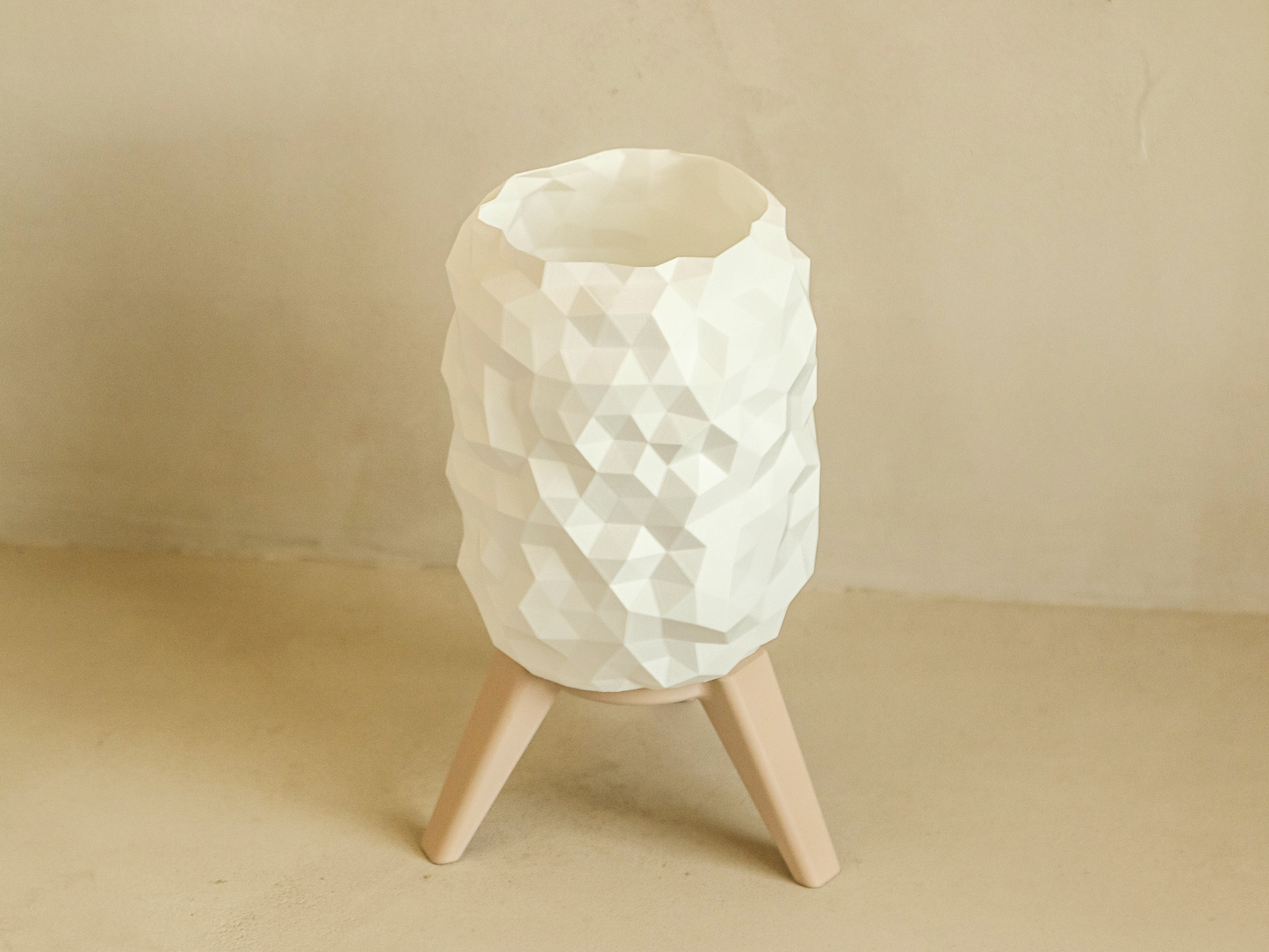 White textured lamp on a beige stand against a beige background