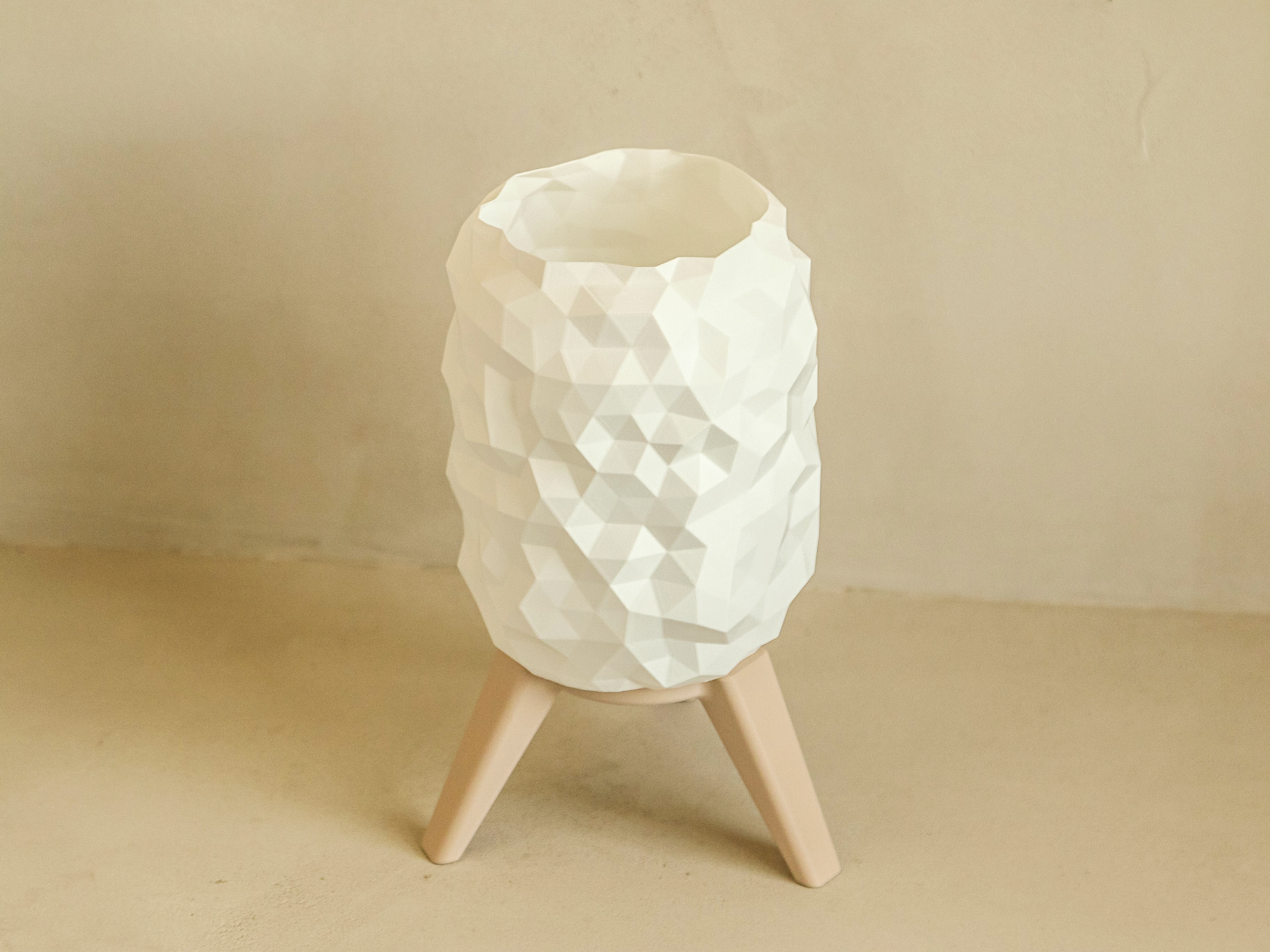 White textured lamp on a beige stand against a beige background