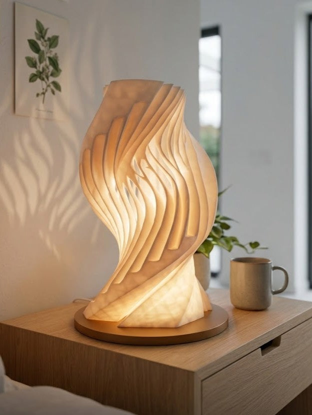 Sculptural wave-inspired table lamp with layered flowing design emitting warm ambient light